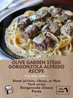 a plate of pasta with meat and cheese on it next to a sign that says olive garden steak gorgonozola alfredo