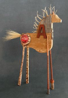 a wooden toy horse with letters on it's body and tail, standing upright