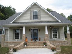 a gray house with white trim and stone steps