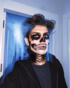 a man with his face painted like a skeleton