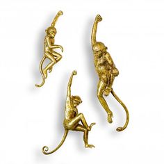 three gold monkey figurines sitting on top of each other, one holding an object