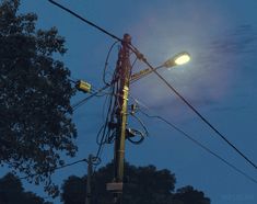 the street light is lit up in the night sky above power lines and telephone wires