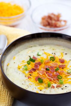 a bowl of soup with cheese and bacon on top