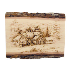 a wooden plaque with an image of a house in the woods on it's side