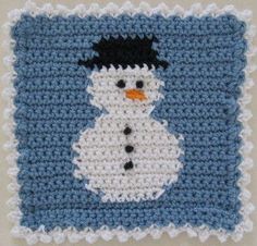 a crocheted snowman on a blue and white square with black trims