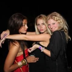 three young women hugging each other at a party