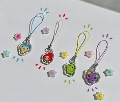 five different shaped key chains with cartoon characters on them, all hanging from the same cord