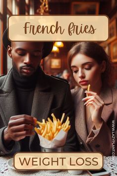 a man and woman sitting at a table eating french fries