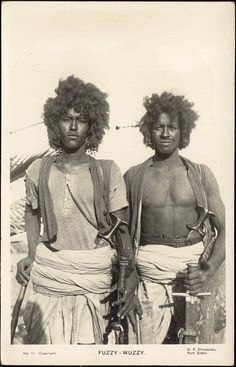 two men with long hair standing next to each other in front of a white background