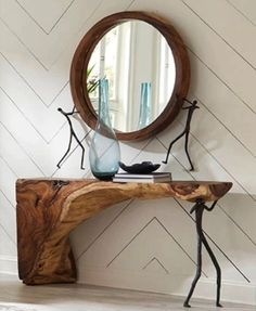 a wooden table with a mirror and vase on it