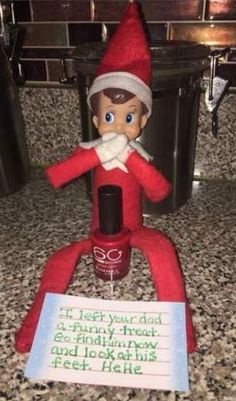 an elf is sitting on the counter next to a sign