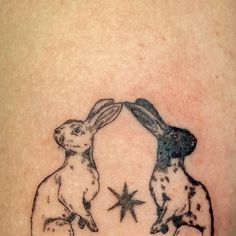 two rabbits sitting on each other in front of the moon with stars around them tattoo