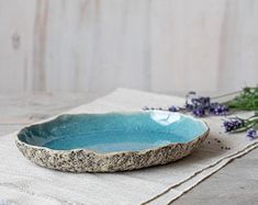 a blue bowl sitting on top of a table next to some lavender sprigs