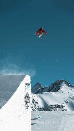 a man flying through the air while riding a snowboard