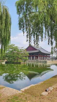 a pond in front of a building with trees around it