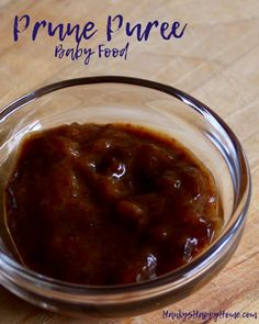 a glass bowl filled with sauce on top of a wooden table