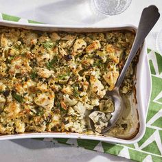 a casserole dish with chicken and vegetables in it on a green tablecloth