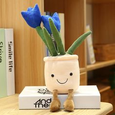 a small potted plant sitting on top of a box with blue flowers in it