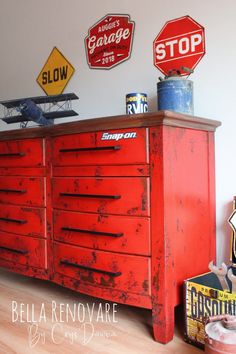 an old dresser is painted red and has several signs on the wall above it that say stop