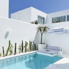 an outdoor pool with plants and chairs next to it