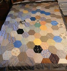 a bed covered in lots of different colored hexagons on it's side