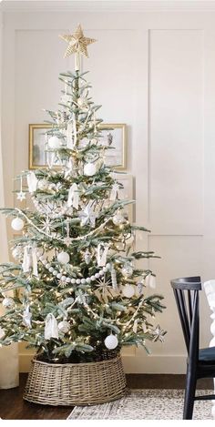 a white christmas tree with ornaments in a basket