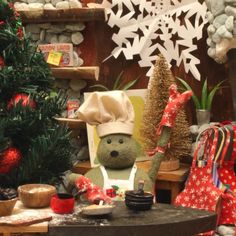 a teddy bear sitting in front of a christmas tree