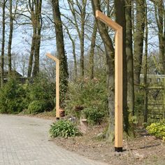 a wooden structure in the middle of a park with trees and bushes around it,