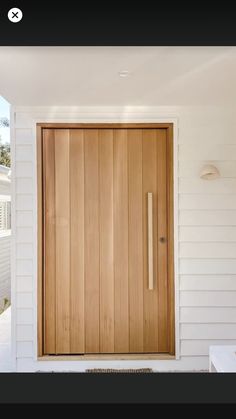 a wooden door in front of a white house