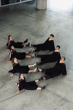 a group of people laying on the ground with their legs spread out and wearing black outfits