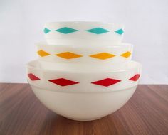 three bowls stacked on top of each other with different colored lines painted on the sides