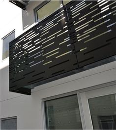 the balcony is made of metal and has vertical slatted screens on it's sides