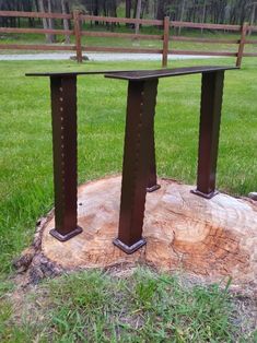 two metal posts sitting on top of a tree stump