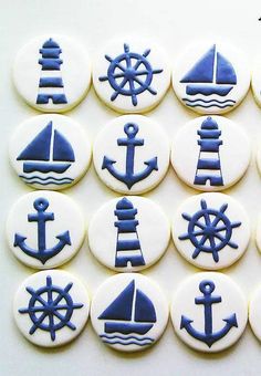 blue and white decorated cookies with ships, boats, and steering wheel on them are arranged in the shape of buttons