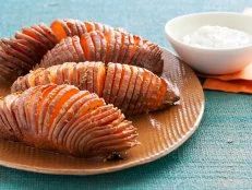 sliced carrots on a plate with dip in a bowl next to it and an orange napkin