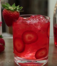 a close up of a drink on a table with strawberries