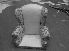 a chair that is sitting on the floor next to some scissors and paper machs