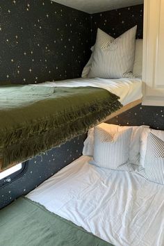 there are two beds in the room with stars on the wall behind them and one bed is made up