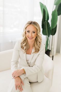 a woman sitting on top of a white couch