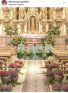 the interior of an ornate church with flowers and greenery on either side of the alter