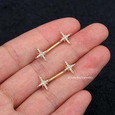 three small gold stars with white crystals on them are in the palm of someone's hand