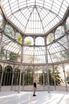 a person standing in a large room with lots of windows on the ceiling and walls