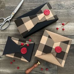 two envelopes with buttons on them sitting next to a pair of scissors