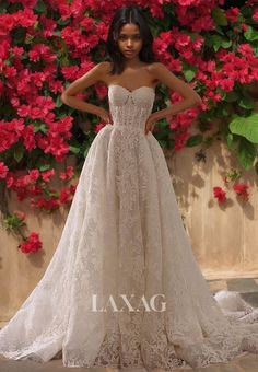 a woman standing in front of flowers wearing a wedding dress