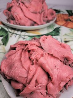 two white plates filled with pink food on top of a floral tablecloth covered table