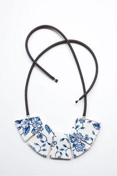 a white and blue necklace with flowers on it