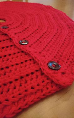 a red knitted blanket with buttons on it