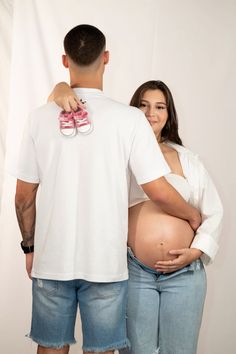 a man and woman standing next to each other with their hands on their stomachs