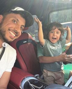 a man sitting in the back seat of a car with a little boy