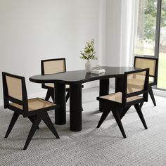 a black table with four chairs around it and a plant in the corner on top